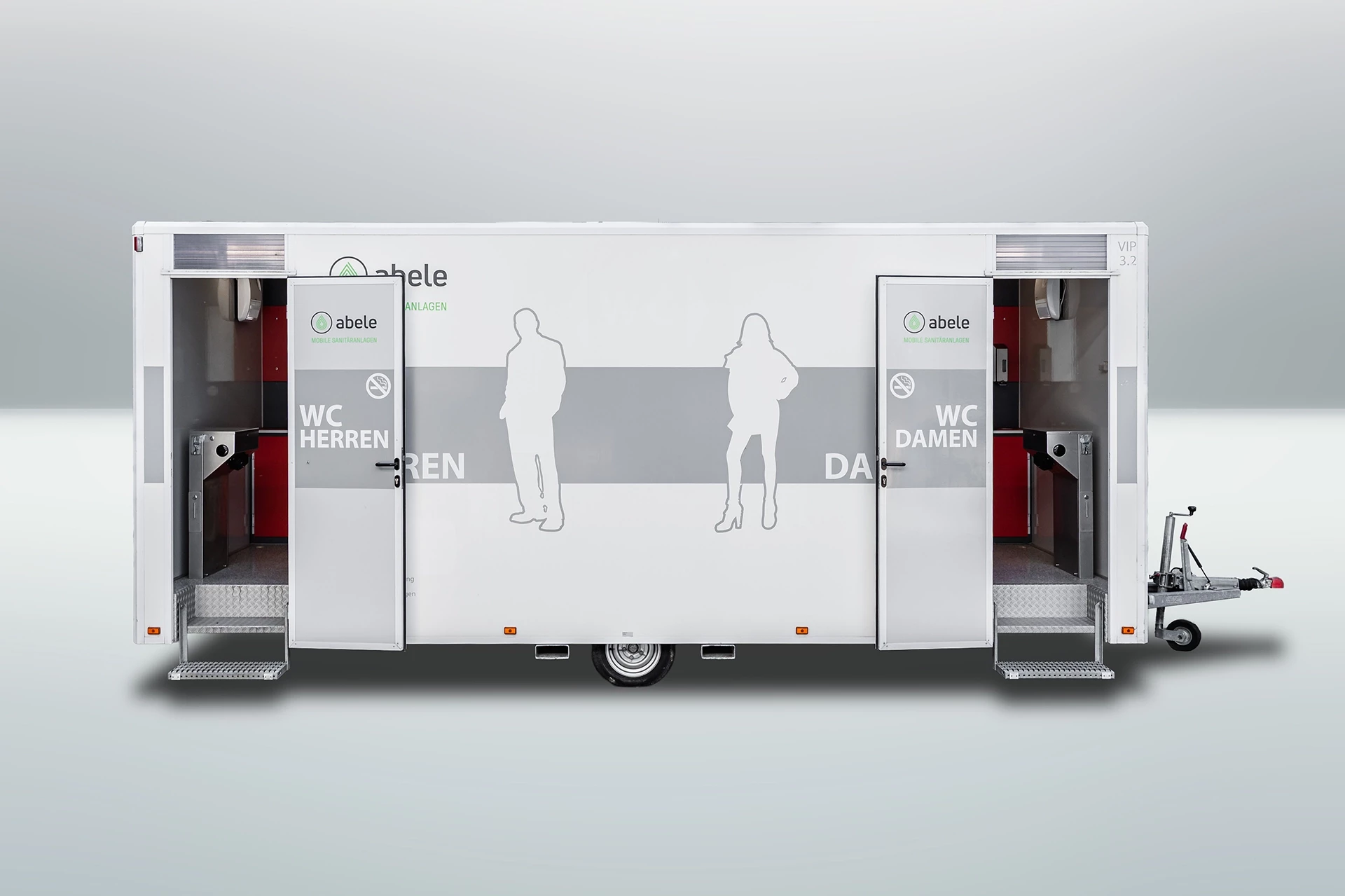 Toilettenwagen Modell Exklusiv – Mix 3/2 2 Mobiler Toilettenwagen mit zwei offenen Türen, aufgeteilt in Herren- und Damensektion, weiß mit Silhouetten und Logo.