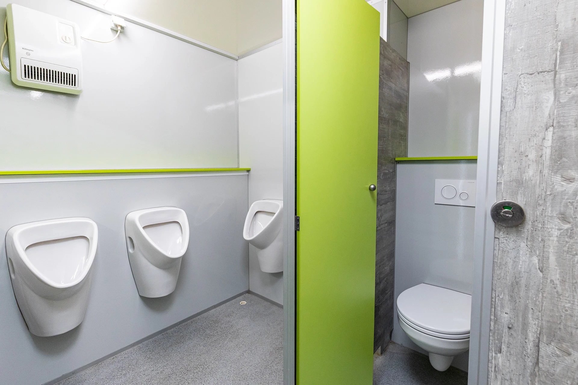 Luxus Toilettenwagen Modell Exklusiv – GoGreen 2 Moderne Toilette mit drei Urinalen links und einer grünen Kabine mit geschlossener Tür und WC rechts.
